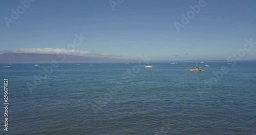 Drone flying between palm trees in Maui. photo