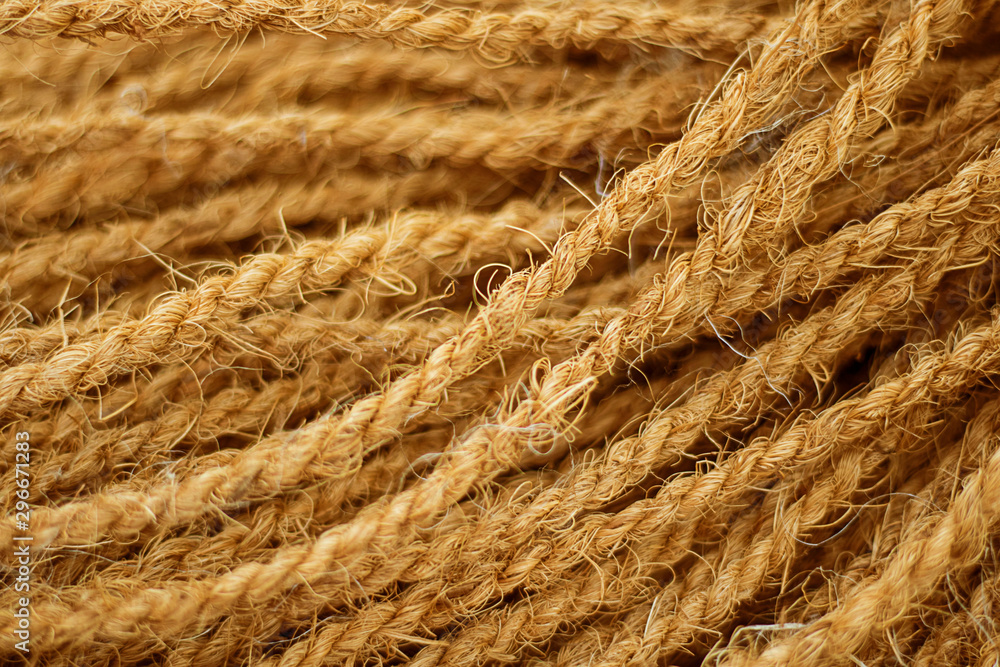 Fototapeta premium Rough Cord made from natural plant fiber. Rope detail, closeup. Wallpaper and background about fabtic manufacture, eco friendly material. Horizontal. Brown tone. Copy space. Selective focus