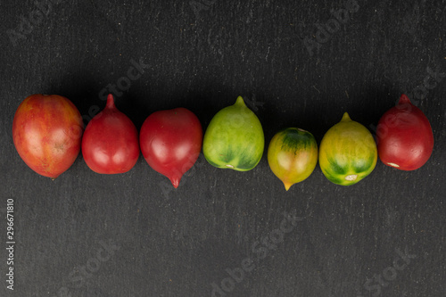 Group of seven whole fresh tomato de barao flatlay on grey stone photo