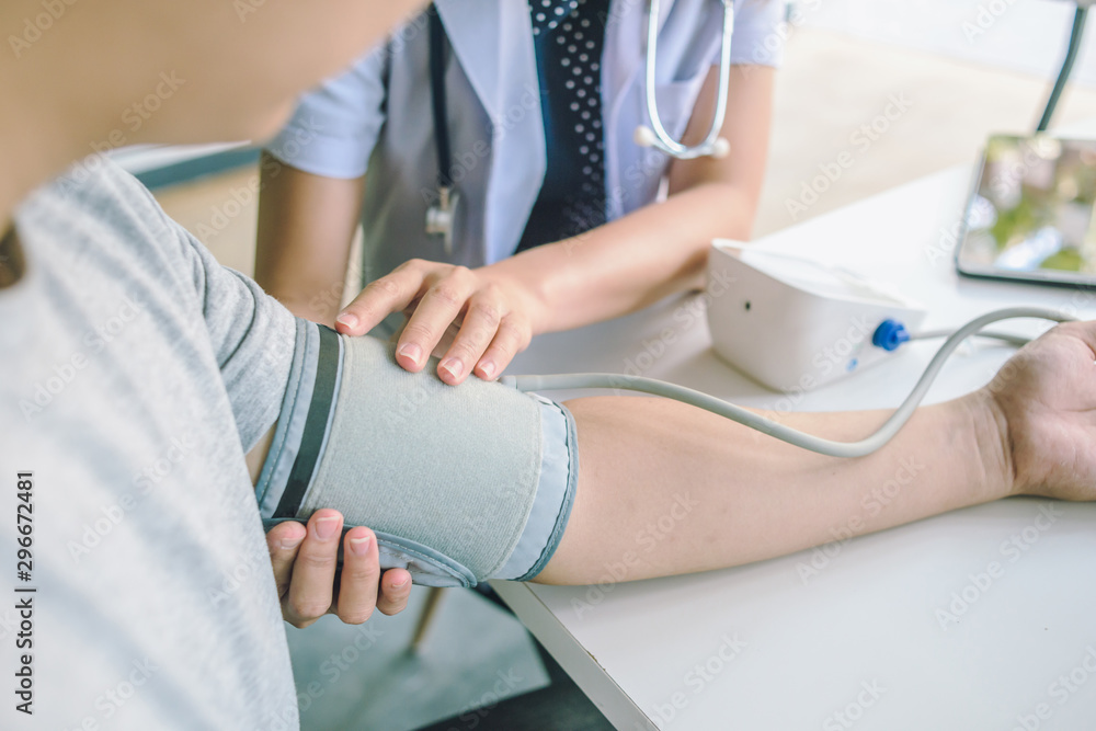 doctor woman checking blood pressure of male patient and heart rate with digital pressure gauge ,Cardiology in medicine and health care concept doctor woman checking blood pressure of male patient and heart rate with digital pressure gauge ,Cardiology in medicine and health care concept