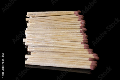 Lot of whole wooden brown safety match in row isolated on black glass