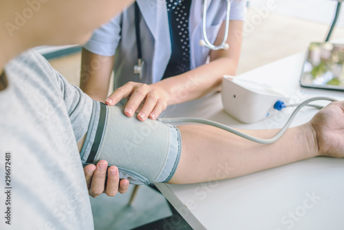 doctor woman checking blood pressure of male patient and heart rate with digital pressure gauge ,Cardiology in medicine and health care concept