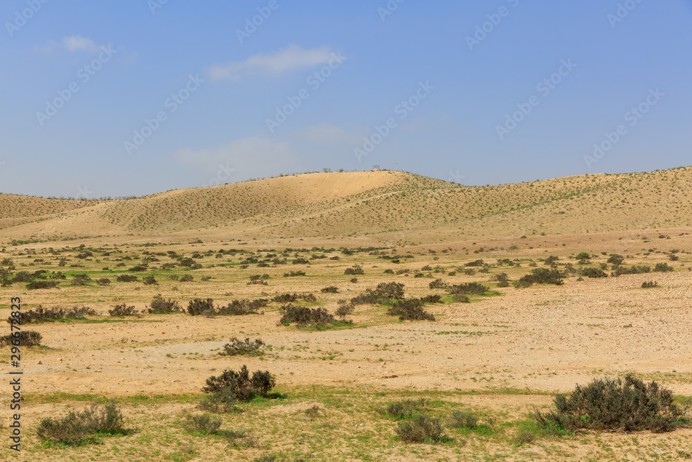 View on far hill with small valley in desert under sky