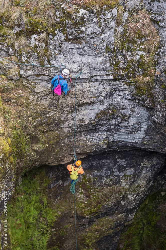 Sumgan-Kutuk karst cave. Cavers descend into the cave. Sumgan-Kutuk karst cave. Cavers descend into the cave.