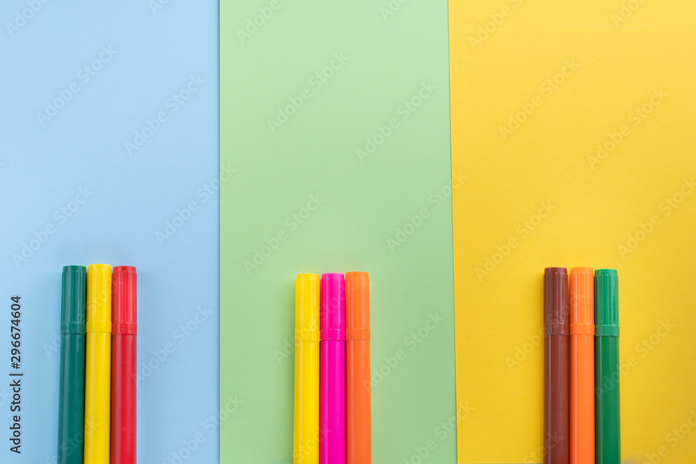 Back to school, minimalism concept. School supplies. Felt-tip pens on pastel trendy blue green yellow color paper background. Copy space, flat lay Back to school, minimalism concept. School supplies. Felt-tip pens on pastel trendy blue green yellow color paper background. Copy space, flat lay