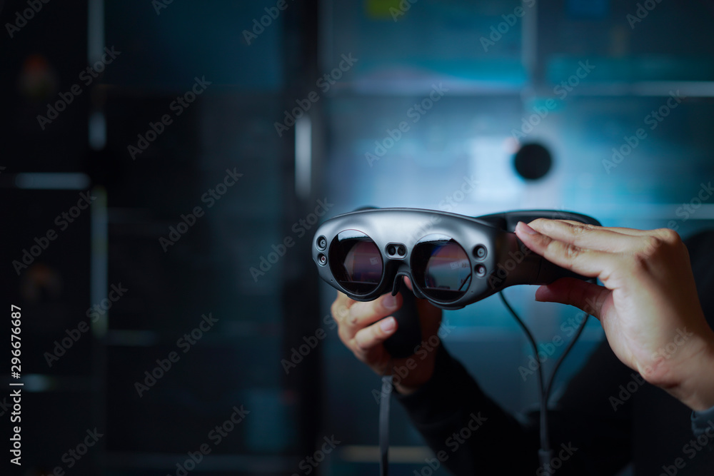 a hand holding ar galsses in a dark room