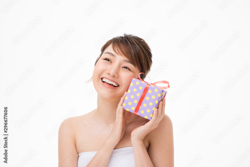 Happy young woman holding small gift box isolated on a white background Happy young woman holding small gift box isolated on a white background