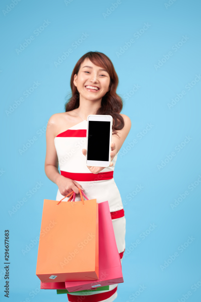 Stylish young woman with shopping bags and smart phone in hands Stylish young woman with shopping bags and smart phone in hands
