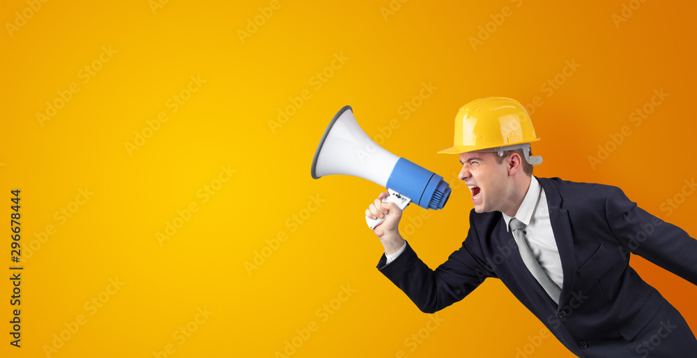 Fototapeta premium Young architect constructor yelling with megaphone and copyspace