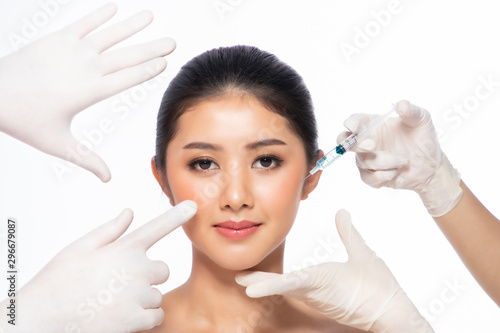 Asian young woman gets injection in her lips. Woman in beauty salon. plastic surgery clinic.Beautiful woman gets injection in her face.