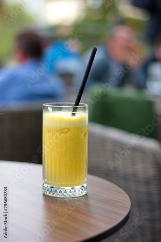 Glass of orange juice with straw on the table in restaurant