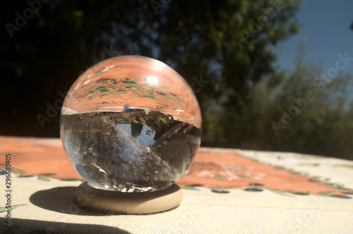 Quartz sphere with inclusions lensing a scene in a Tuscan garden