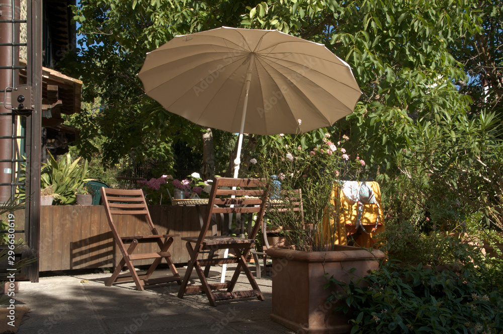 Seating group with parasol by Tuscan villa, region of Florence