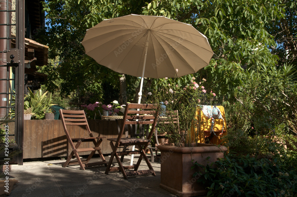 Seating group with parasol by Tuscan villa, region of Florence