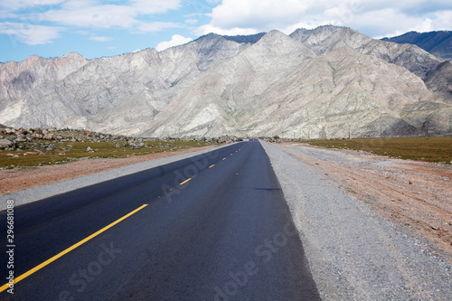 Asphalt road leading to the mountains. Yellow road markings.