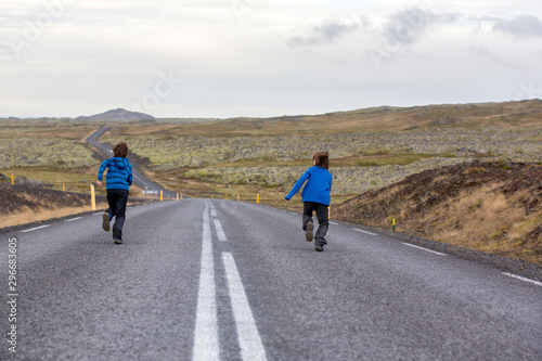 Kids running on an empty road in beautiful nature in Snaefellsjokull National Park in Iceland  autumntime
