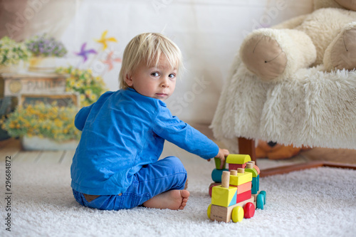 Sweet toddler child, playing doctor, examining teddy bear toy