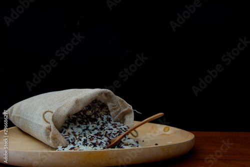 Close Up Photo of Brown/Coarse Rice and Thai Jasmine Rice and Riceberry mixed in The Sack Bag with Wooden Spoon