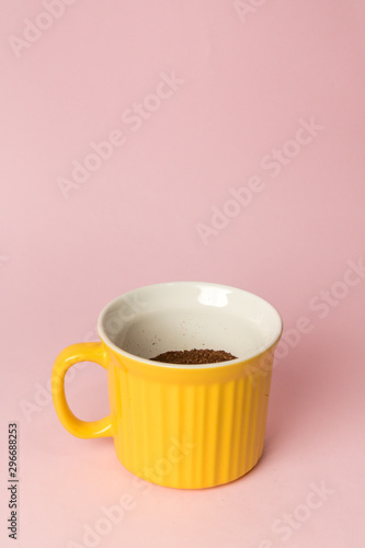 yellow cup with coffee on pink background