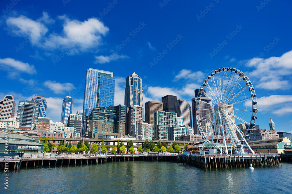 Seattle Ferris wheel, skyline and waterfront sunny day with blue sky and clouds. Seattle Ferris wheel, skyline and waterfront sunny day with blue sky and clouds.