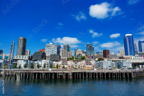 Seattle Ferris wheel, skyline and waterfront sunny day with blue sky and clouds.