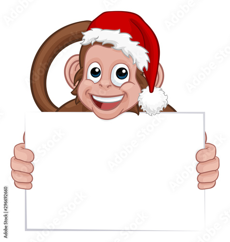 A Christmas monkey animal cartoon character in a Santa hat holding a sign