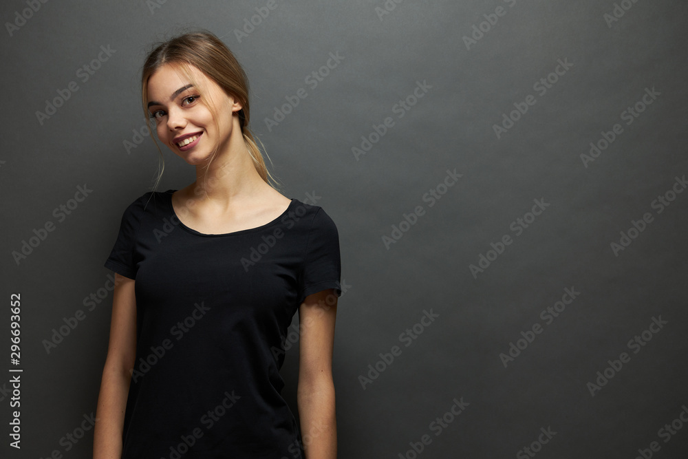 Sexy woman or girl wearing black blank t-shirt with space for your logo, mock up or design in casual urban style over gray background Sexy woman or girl wearing black blank t-shirt with space for your logo, mock up or design in casual urban style over gray background
