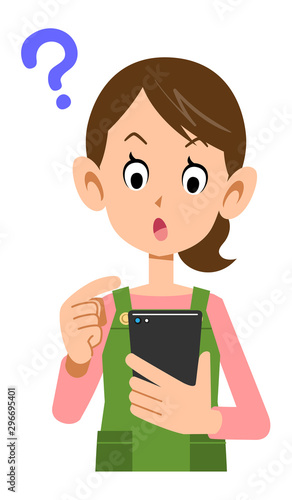 スマートフォンを操作するエプロンを着けた女性の疑問の表情