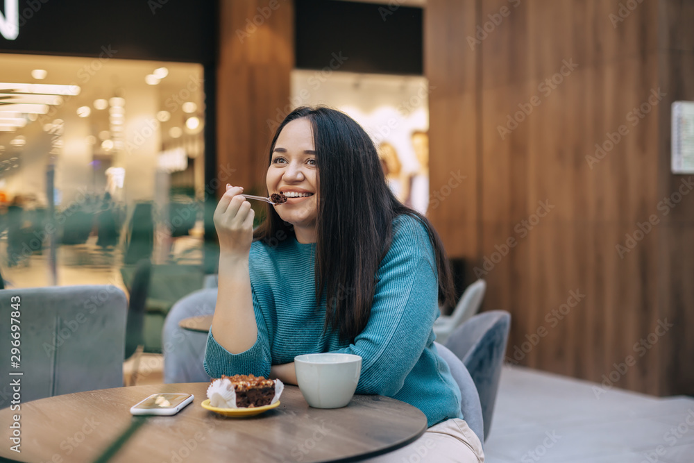 Cute plus size woman resting in cafe inside city mall Cute plus size woman resting in cafe inside city mall