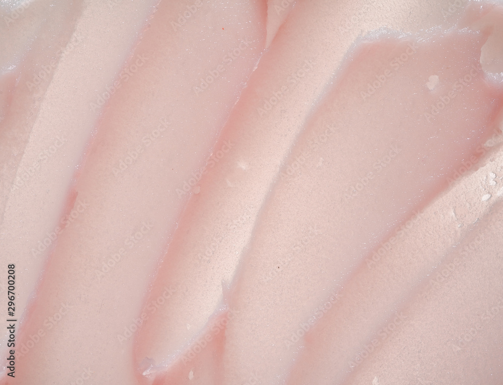 Fototapeta premium Delicate pink texture and strokes of a cosmetic face mask or cream on a white background