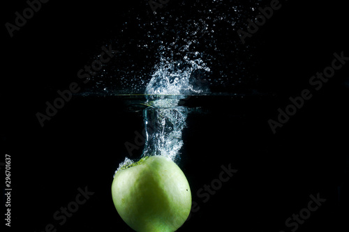 Water splash and fruits isolated on black backgroud. Fresh Apple.