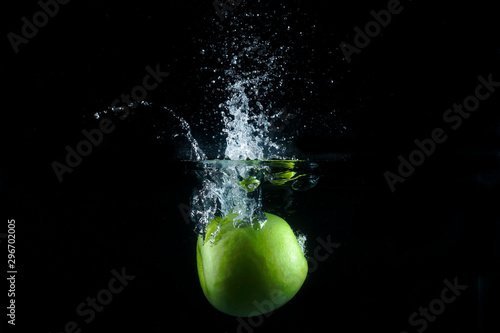 Water splash and fruits isolated on black backgroud. Fresh Apple.
