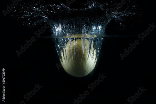 Water splash and fruits isolated on black backgroud. Fresh Lemon and Pear.