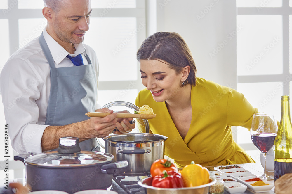 Smiling young couple cooking food in the kitchen Smiling young couple cooking food in the kitchen