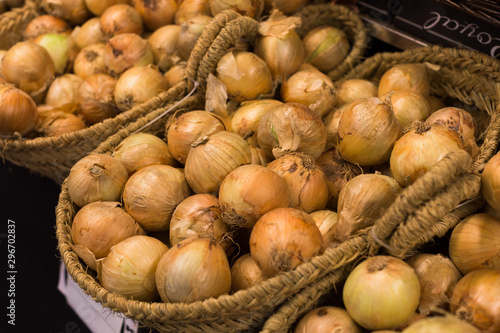 bulb onion in wicker baskets on market counter