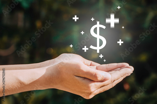 Women hands hold a money bags and dropping on the top in the public park for loans to planned investment in the future concept.