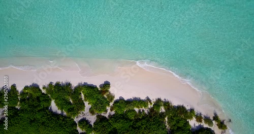 Aerial drone corcscrew shot over the white sand seychelles beach and turquoise crystal clear sea vater. photo