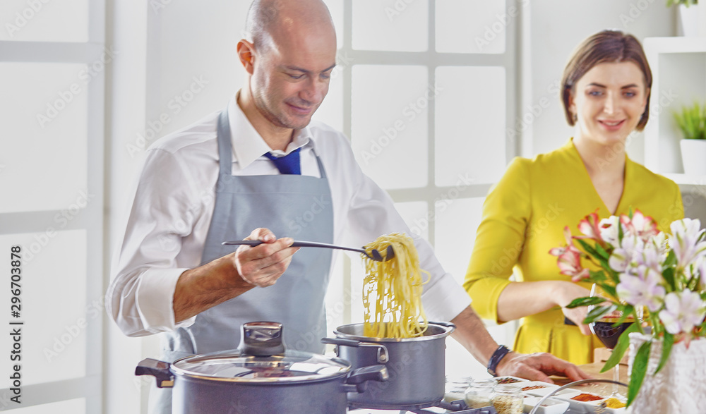 Smiling young couple cooking food in the kitchen