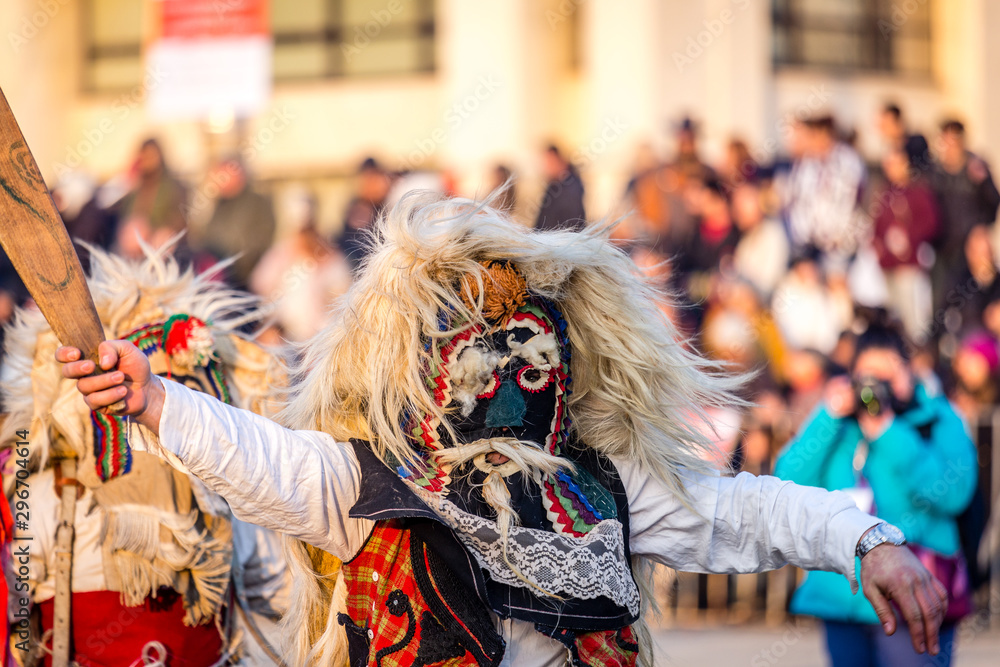 Mummers perform rituals to scare evil spirits at Surva festival at Pernik in Bulgaria. The people with the masks are called Kuker (kukeri). Wool mask and wood sword.