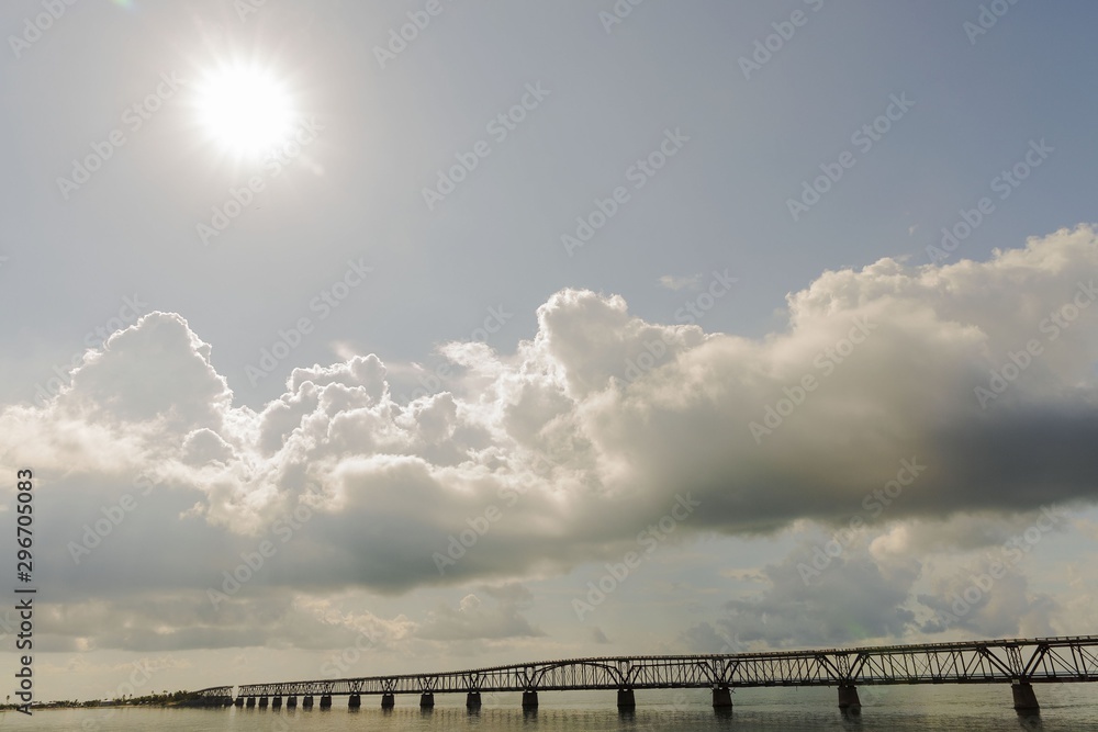 Highway to Key West Florida. View of old abandoned bridge and coast line of Atlantic ocean on blue sky with numerous clouds background. Florida. USA.