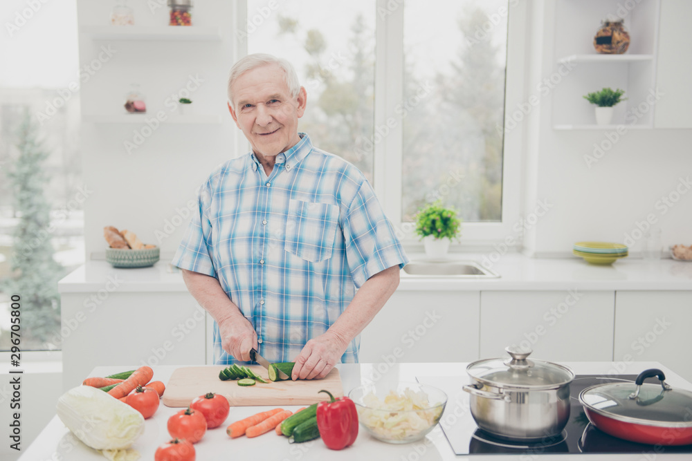 Portrait of his he one single nice attractive lovely cheerful cheery granddad cooking fresh delicious dishes in modern light white interior kitchen indoors Portrait of his he one single nice attractive lovely cheerful cheery granddad cooking fresh delicious dishes in modern light white interior kitchen indoors