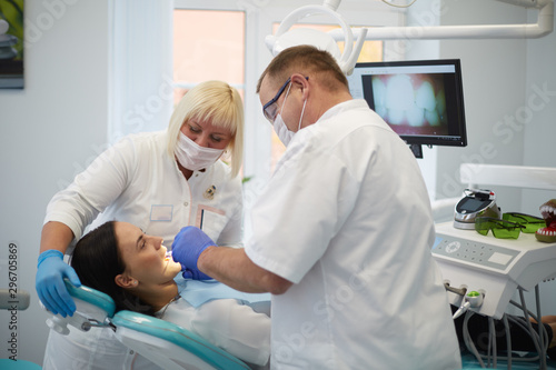 Doctor dentist treats teeth of a beautiful young girl patient. The girl on reception at the dentist. Doctor dentist treats tooth