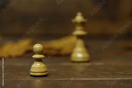 Chess pieces on a blurry brown background.dreams of becoming a queen