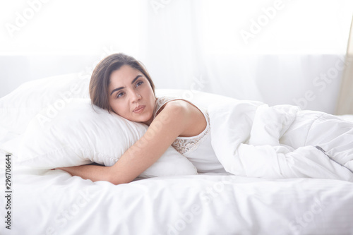 beautiful young woman basking in bed in the morning. Beautiful Model face looks sexy in camera