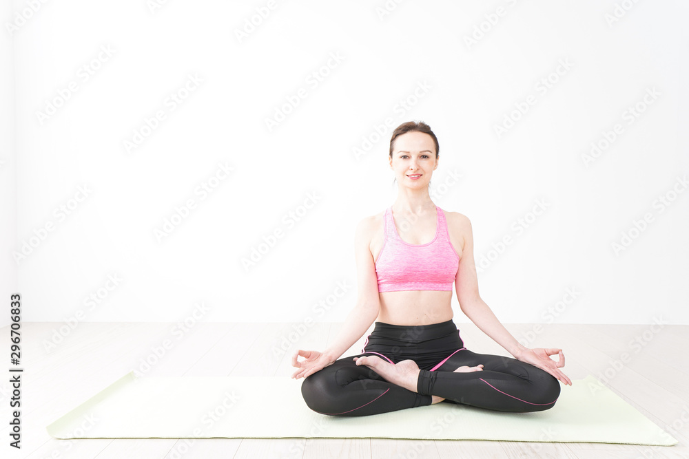 スポーツウェアを着てヨガをする外国人の女性