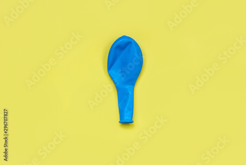 holiday concept, bursting neoplastic blue balloon on a bright yellow background photo