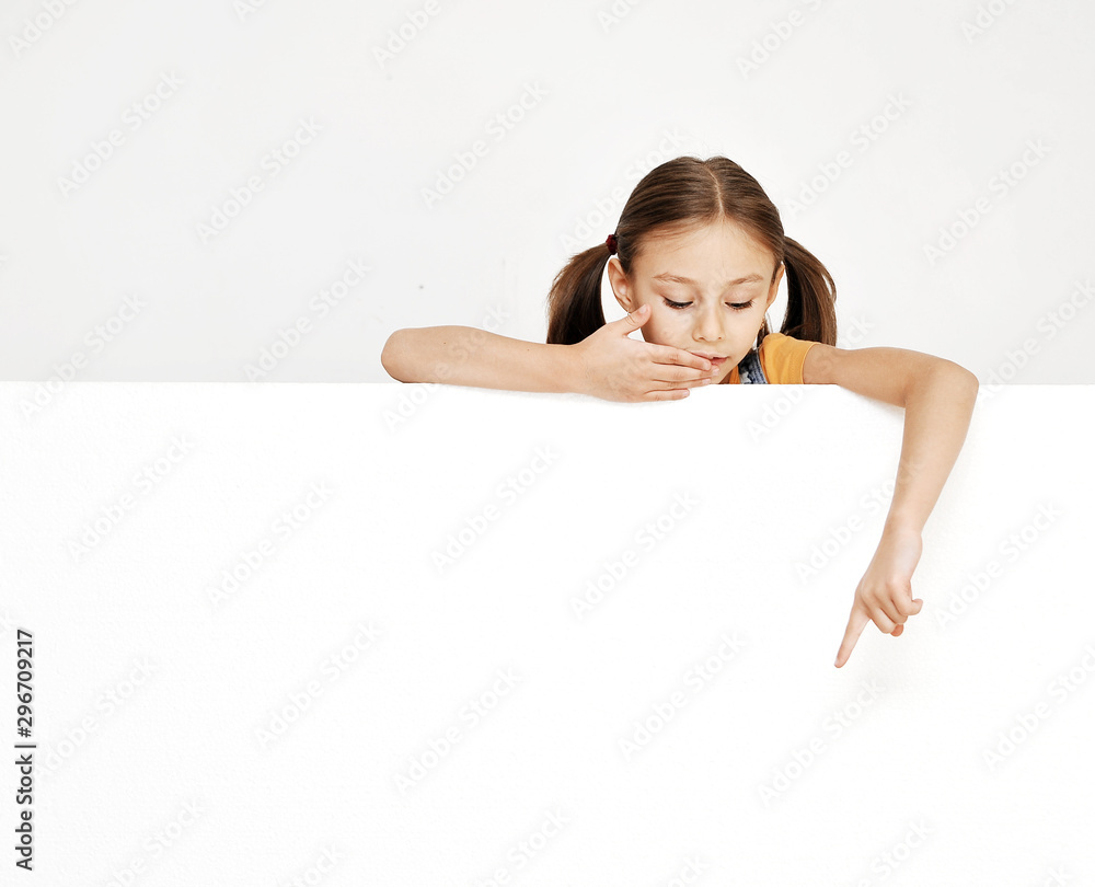 Little thinking girl holds white banner with copy space. Little thinking girl holds white banner with copy space.