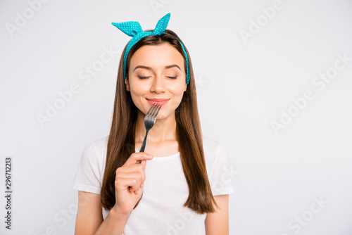 Portrait of inspired dreamy girl hold fork feel hungry want eat imagine tasty meal delicious burger close eyes wear stylish blue headband t-shirt isolated over white color background photo