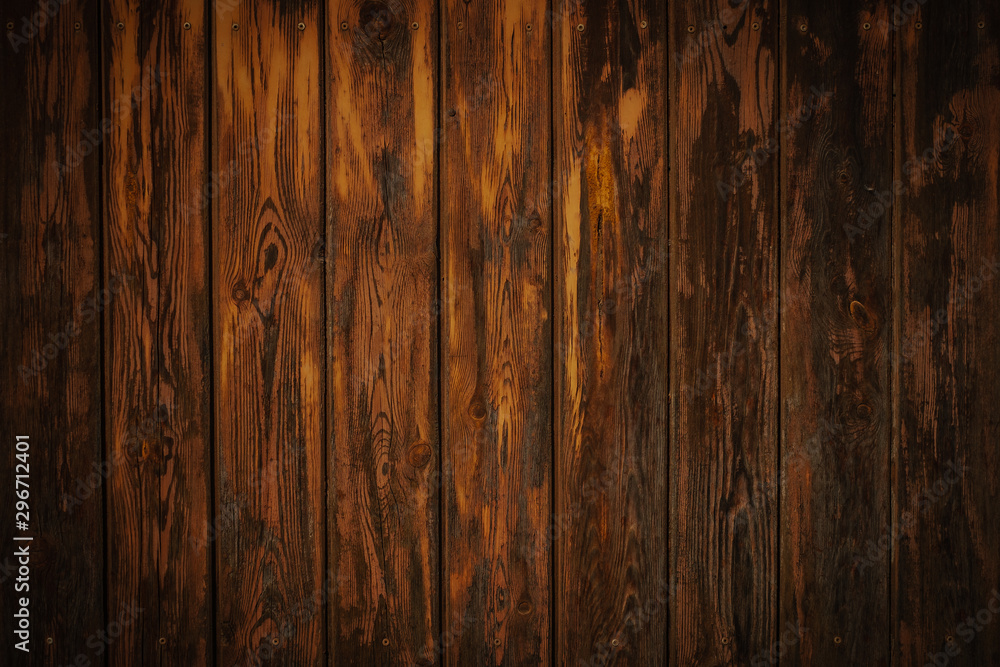 Dark brown wooden boards with a worn surface. Old wooden background texture with vertical pattern. Dark brown wooden boards with a worn surface. Old wooden background texture with vertical pattern.