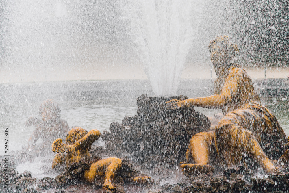 Une statue et une fontaine dorée à Versailles. Un bassin avec des